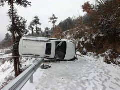 轿车在积雪路面失控 侧翻倒在路边栏杆上