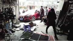 女司机低头捡手机 车子失控冲进门店