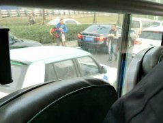 商贩穿梭在车流中售卖商品   脖子上还缠着方向盘套