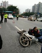 男子坐在地上  身旁还有一辆翻倒的摩托车